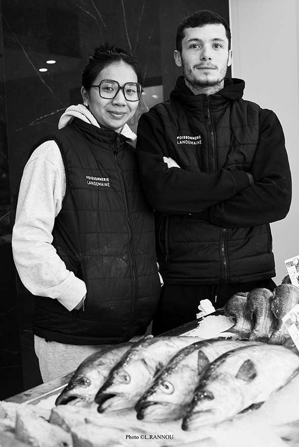 Portrait en noir et blanc de Marine et Oscar, les nouveaux gérants souriants de la poissonnerie Landemaine à Plescop, dans leur magasin